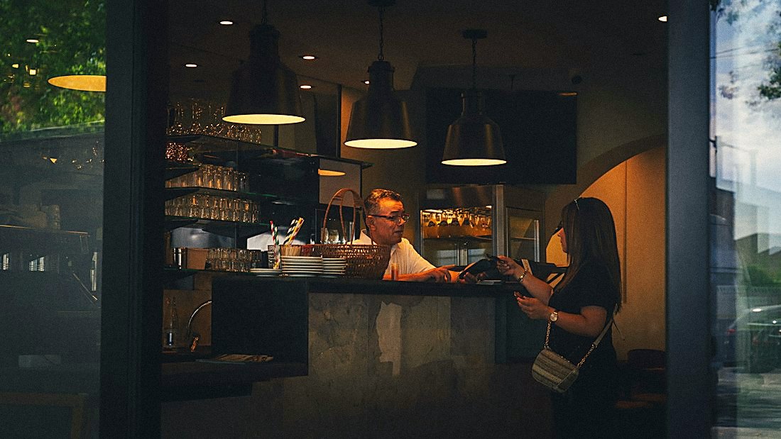 A guest paying at a restaurant bar