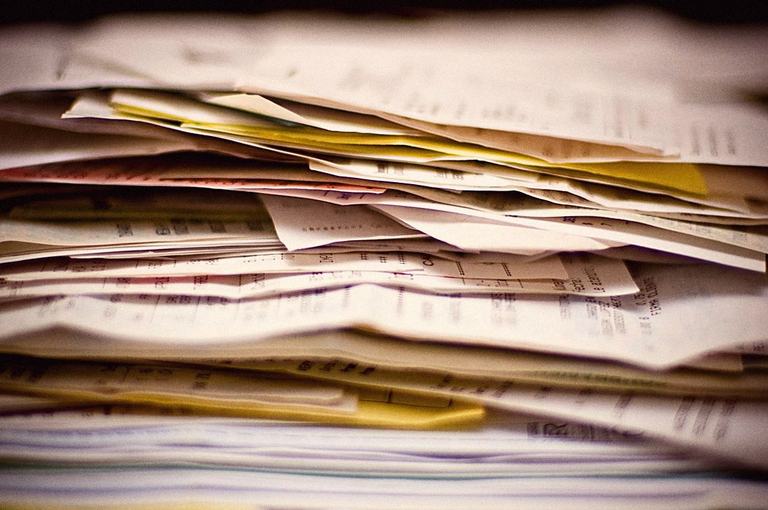 A tall stack of paper invoices