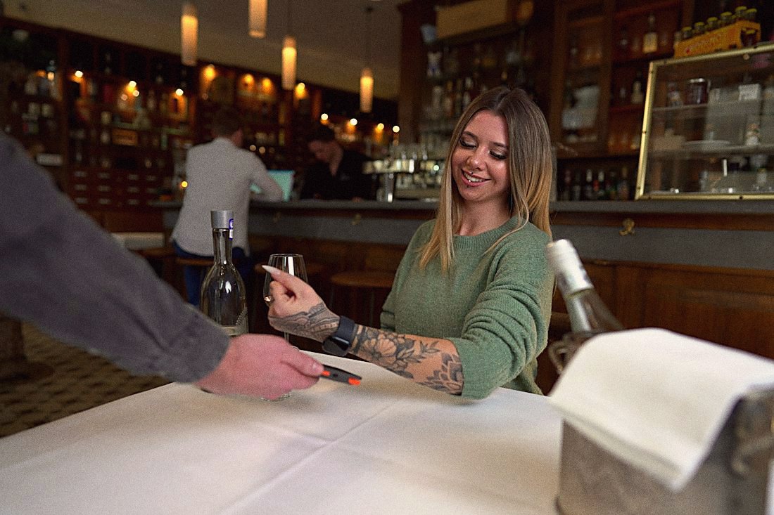 A guest paying with a phone at a restaurant counter